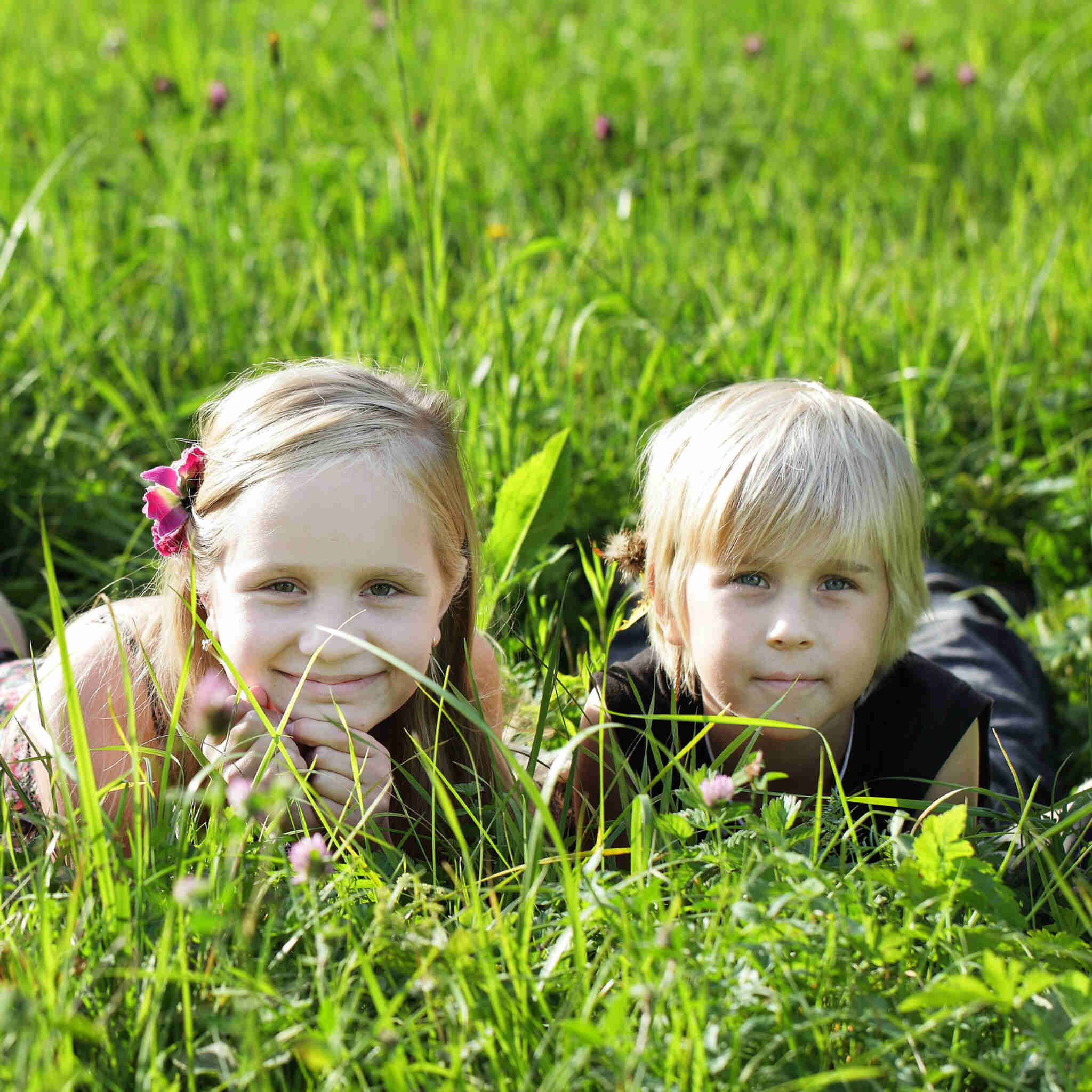 dzieci-lezace-na-letniej-trawie-na-swiezym-powietrzu_Easy-Resize.com